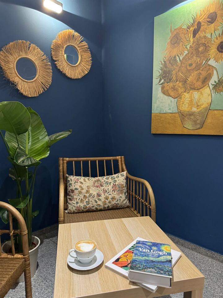 Gemütliche Kaffeeecke mit Sessel und Sonnenblumen-Bild im Familiencafé Zauberbaum